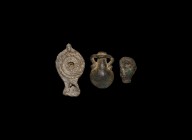 Roman Votive Object Group
1st century BC-1st century AD. A mixed votive group comprising: a lead miniature oil lamp; a bronze amphora flask; a green ...
