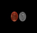 Roman Intaglio Gemstone with Standing Figure
2nd-3rd century AD. An oval red carnelian intaglio gemstone engraved with a togate male figure leaning o...