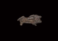 Roman Boar Plate Brooch
2nd century AD. A bronze plate in the form of a boar, scroll and pellet decoration to the body; pin, pin-lug and catchplate t...