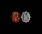 Roman Gemstone with Standing Figure
2nd-3rd century AD. A red carnelian intaglio engraved with a standing figure, facing left, holding a staff(?"). 0...