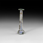 Roman Tall Glass Vessel
1st-3rd century AD. A glass unguentarium perfume bottle with squat domed body and recessed underside, tapering neck with spla...