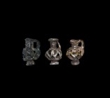 Roman Miniature Glass Jug Group
1st-3rd century AD. A group of three miniature glass jugs, bulbous openwork body formed around a central central core...