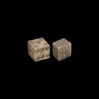 Roman Bone Dice Pair
1st-3rd century AD. A pair of bone dice, the smaller one irregular in shape, both with ring-and-dot markings arranged 1:6, 2:5, ...