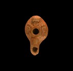 Roman Oil Lamp with Flowers
Eastern Empire, 5th century AD. A squat ceramic piriform oil lamp with basal ring, nozzle with scooped finial, broad shou...