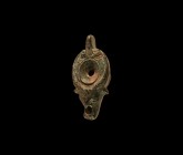 Roman Votive Oil Lamp with Ox-Head
1st-2nd century AD. A bronze miniature oil lamp with discoid base, bulbous body, nozzle formed as a bull's head, t...