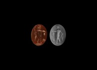 Roman Intaglio Gemstone with Standing Deity
2nd-3rd century AD. An oval red carnelian intaglio gemstone engraved with a standing deity, holding a cro...