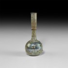 Roman Iridescent Vase with Trail
1st-2nd century AD. A globular iridescent glass jar with dimple base, tubular neck with flared rim. 61 grams, 18cm (...