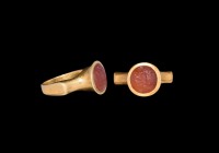 Roman Gold Ring with Fortuna Gemstone
3rd-4th century AD. A gold ring comprising a slender D-section hoop, scooped shoulders, trumpet-shaped bezel, i...