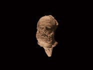 Roman Bearded Head Fragment
1st-2nd century AD. A moulded ceramic male head with beard, plain to the reverse, conical peg to the underside. 78 grams,...