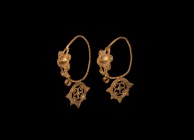 Byzantine Gold Earrings with Granular Decoration
5th-8th century AD. A matching pair of gold earrings, each a twisted oval hoop with applied ropework...
