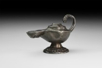 Byzantine Silver Oil Lamp with Lion Handle
10th-12th century AD. A sheet silver lamp with stepped disc base and billeted band, slipper-shaped body wi...