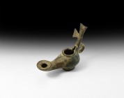 Byzantine Oil Lamp with Cross Handle
7th-9th century AD. A bronze oil lamp with globular heart-shaped body and projecting nozzle with wide wick hole;...