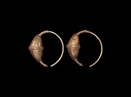 Byzantine Gilt Temple Ring Pair
7th-10th century AD. A matched pair of gilt metal temple rings, each a biconvex bulb with applied filigree bands, hoo...