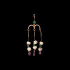 Byzantine Gold Earring with Emeralds and Rubies
6th-8th century AD. A gold earring formed as a loop with emerald stud and granulated collar, ?-shaped...