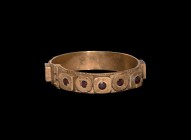 Western Asiatic Gold and Garnet Bracelet
1st century BC-2nd century AD. A gold bracelet formed as a flat sheet with raised alternating square and rou...