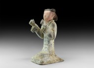 Chinese Han Kneeling Figure Statuette
Han Dynasty, 206 BC-220 AD. A ceramic statuette of a kneeling male figure in a white robe with arms bent and ha...