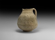 Gandharan Vessel with Figural Scenes
2nd-4th century AD. A ceramic jug with discoid base, lotus flower pattern to the underside, frieze of pairs of f...