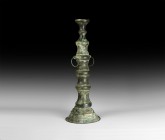 Islamic Lamp Stand Pillar
13th-14th century AD and later. A hollow-formed bronze lamp stand with tiered balustered body, lateral rings, slot to the u...