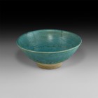 Islamic Glazed Bowl
12th-13th century AD. A turquoise glazed deep footed bowl with turned rim, band of incised dot-decoration to the inside wall, pai...