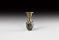 Islamic Ribbed Glass Vessel
9th-10th century AD. An aqua glass bottle, ovoid in profile with pinched vertical ribs extending to stub feet, bell-shape...