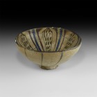 Islamic Glazed Bowl with Flower
13th century AD. A cream glazed footed bowl, inside with dark brown flower with six petals, blue radiating lines in b...