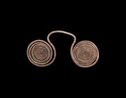 Bronze Age Silver Spectacle Pendant
16th-10th century BC. A silver pendant formed as two coils of round-section rod, large loop between. 42 grams, 11...