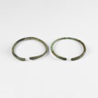 Bronze Age Bracelet Pair
2nd millennium BC. A pair of bronze penannular bracelets, round-section with flattened terminals, one decorated with cross-h...