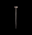 Bronze Age Silver Propeller-Headed Cloak Pin
2nd millennium BC. A silver dress pin comprising a tapering round-section shaft with ribbed upper end, s...