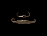 Bronze Age Dress Fastener Pair
1st millennium BC. A pair of bronze fasteners comprising: a flat-section with hooked terminals, pierced through the mi...