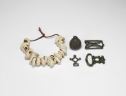 Viking Artefact Group
9th-11th century AD. A mixed group of artefacts comprising: a string of cowrie shell pendant; a lead(?) bell; a bronze buckle w...