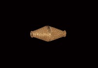 Viking Gold Biconical Bead
7th century AD. A sheet gold biconical bead formed as two conjoined funicular elements with beaded wire collars to the out...