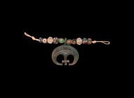 Viking Lunar Pendant with Cross and Beads
10th-12th century AD. A necklace group comprising a graduated collection of glass and crystal beads, bronze...