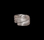 Viking Decorated Silver Bracelet
9th-11th century AD. A silver coiled bracelet with overlapping tapered ends, three raised bands to the outer face, p...
