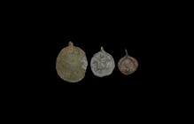 Viking Pendant Group
10th-12th century AD. A mixed group of bronze pendants comprising: a disc with punched annulets and cruciform motif, applied str...