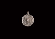 Viking Silver Scutiform Pendant
9th-11th century AD. A silver discoid pendant with raised boss, decorated with stamped chevrons, annulet to each corn...