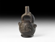 Pre-Columbian Figural Vessel
1st millennium AD. A burnished ceramic stirrup jar with flared base, stylised facial details to the body, conjoined tube...