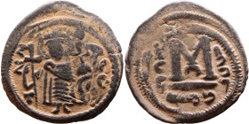 al-Malik ibn Marwan (687-705), Byzantine style folis Obverse: Imperial figure holding globe and cross Reverse: M and inscription

Weight:23mm 4,21g...