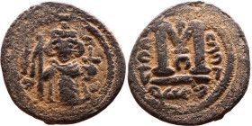 al-Malik ibn Marwan (687-705), Byzantine style folis Obverse: Imperial figure holding globe and cross Reverse: M and inscription

Weight:21mm 4,14g...