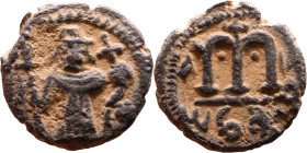 al-Malik ibn Marwan (687-705), Byzantine style folis Obverse: Imperial figure holding globe and cross Reverse: M and inscription

Weight:17mm 3,41g...