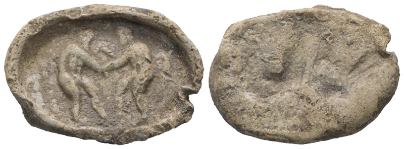 PB Greek tessera (c. 5th–4th century BC).
Obv.: Two nude wrestlers, standing and...