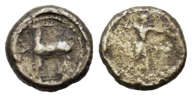 Italy, Bruttium, Kaulonia, c. 475-425 BC. AR Nomos (9,7mm, 1g). Apollo advancing r., holding branch; small daimon running r. on Apollo's l. arm; [to r...