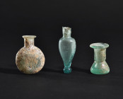 ARQUEOLOGÍA. ROMA. Lote de 3 pequeños ungüentarios (ss. I-IV d.C.). Vidrio con irisaciones. Altura de 3,5 a 5,6 cm. Uno de ellos presenta falta en la ...