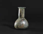 ARQUEOLOGÍA. ROMA. Ungüentario de cuerpo globular achatado, cuello ancho y cilíndrico y boca exvasada (ss. I-IV d.C.). Vidrio con irisaciones. Altura ...
