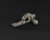 ARQUEOLOGÍA. ROMA. Fíbula cruciforme con decoración de círculos concéntricos (ss. I-IV d.C.). Bronce. Longitud 8,4 cm.