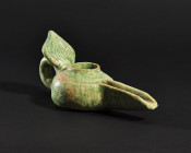 ARQUEOLOGÍA. MUNDO ISLÁMICO. Lucerna con decoración de hoja en su asa (ss. X-XII). Cerámica vidriada. Longitud 18 cm.