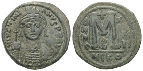 Justinian I, AD 527-565. AE, Follis. 16.43 g. 33.72 mm. Nicomedia.
Obv: DNIVSTINI-ANVS PPAVC. Frontal bust of Justinian I wearing helmet with plume, d...