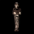 New Kingdom, 19th Dynasty, 1279-1213 B.C. The mummiform figure in brownish-black and white faience with black detailing, wears a round wig featuring a...