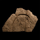 Late Period, 664-332 B.C. A fragment featuring a low-relief depiction of a male head in profile with a shoulder-length duplex wig, the upper part intr...