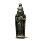 Third Intermediate Period, circa 1069-735 B.C. Modelled in the round, formed as the goddess standing before a high-backed throne cradling the head of ...