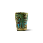 New Kingdom, 20th Dynasty, circa 1183-1152 B.C. Ritual cup with sides tapering towards the base; the black glazed rectangular panel containing two col...